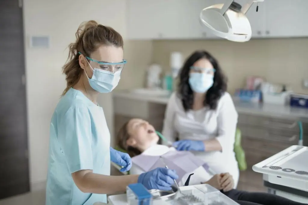 Dentist and Dental Hygienist discuss patient in chair.